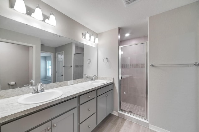 bathroom with wood-type flooring, vanity, and walk in shower