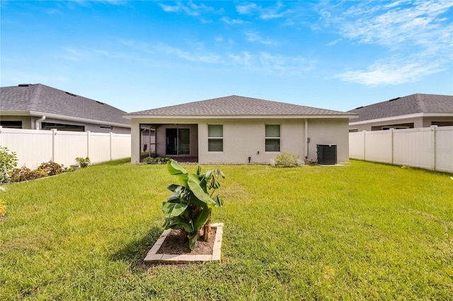 back of property featuring a lawn and central air condition unit