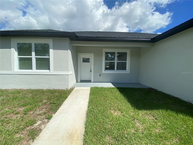 property entrance with a lawn