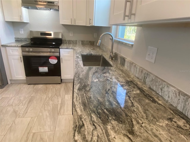 kitchen with stainless steel range, white cabinets, and sink