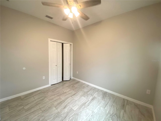 unfurnished bedroom with ceiling fan and a closet