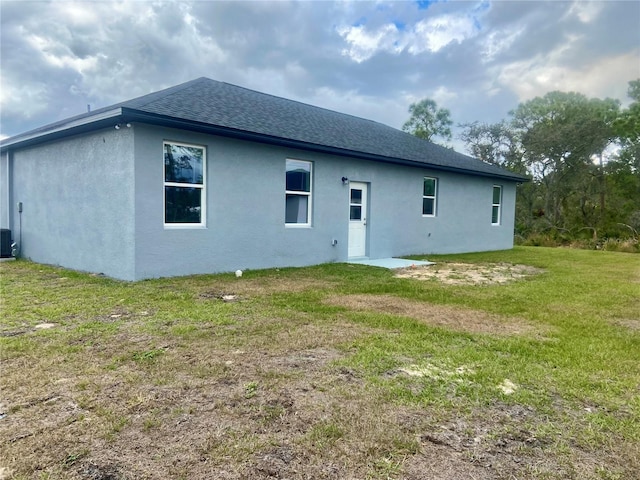 back of house featuring a lawn and cooling unit