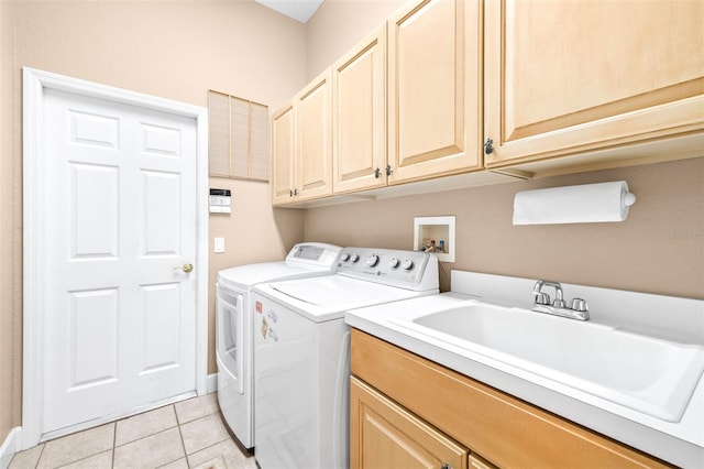 laundry area featuring light tile patterned floors, cabinets, sink, and washer and dryer