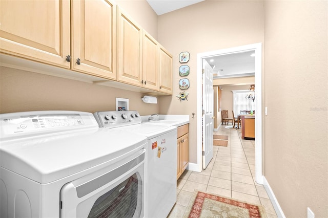 washroom featuring cabinets, washing machine and clothes dryer, light tile patterned floors, and sink