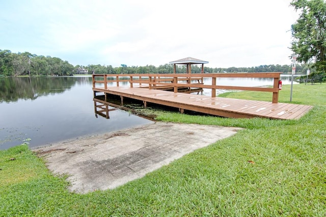 view of dock featuring a water view, a gazebo, and a yard