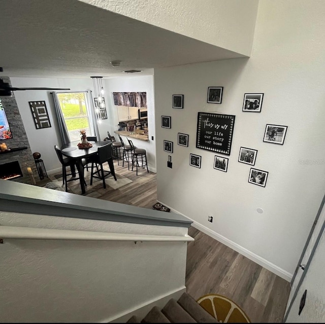 staircase with a fireplace and wood-type flooring