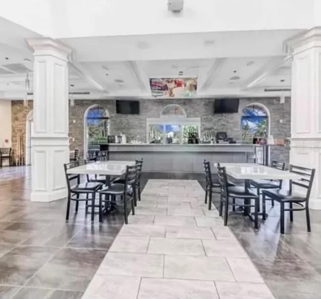 dining room with coffered ceiling, ornate columns, and beam ceiling