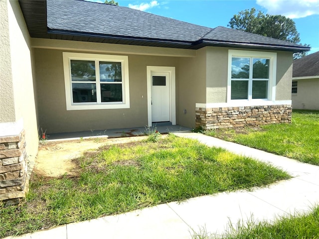 view of exterior entry with a lawn