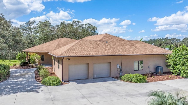 view of front of home with a garage and central AC unit