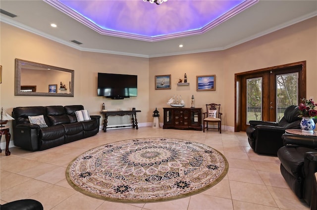 tiled living room with french doors, a tray ceiling, and ornamental molding