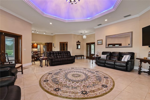 tiled living room featuring an inviting chandelier, ornamental molding, french doors, and track lighting