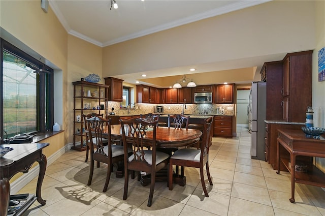 dining area with light tile patterned flooring, ornamental molding, and sink