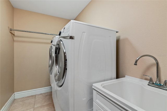 washroom featuring washer and clothes dryer, sink, and light tile patterned floors