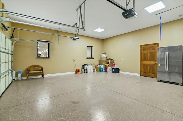 garage with stainless steel fridge and a garage door opener