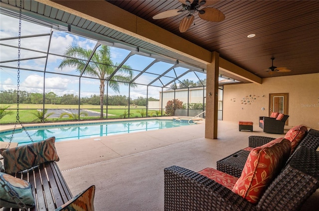 view of pool featuring glass enclosure, an outdoor living space, a patio area, and ceiling fan