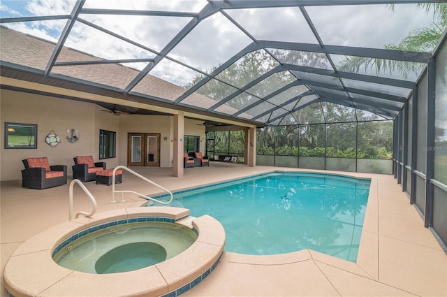 view of swimming pool featuring glass enclosure, an in ground hot tub, french doors, and a patio area