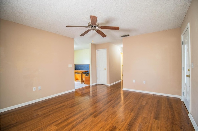 spare room with ceiling fan, a textured ceiling, and dark hardwood / wood-style flooring