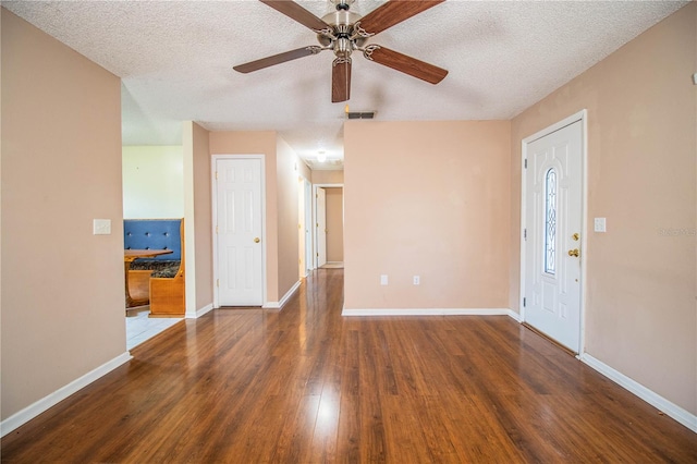 foyer featuring ceiling fan, a textured ceiling, and dark hardwood / wood-style flooring