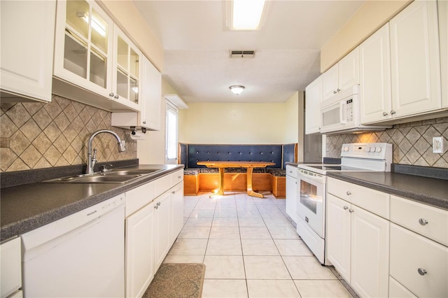 kitchen with backsplash, sink, light tile patterned flooring, white cabinets, and white appliances