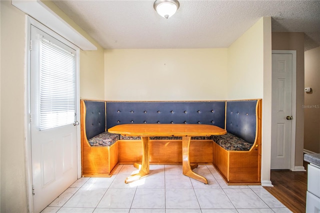 dining room with a textured ceiling, breakfast area, and light tile patterned floors