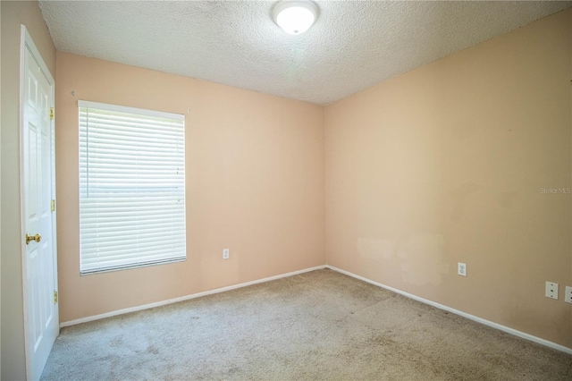 carpeted spare room with a textured ceiling