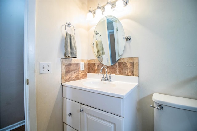 bathroom featuring vanity, toilet, and tasteful backsplash