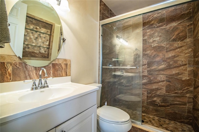 bathroom with backsplash, vanity, toilet, and an enclosed shower