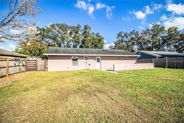 rear view of property featuring a yard