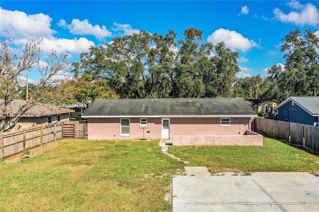 rear view of property featuring a patio area and a yard