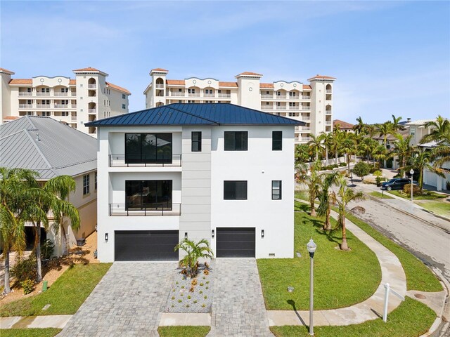 view of front facade featuring stucco siding, a balcony, decorative driveway, and an attached garage