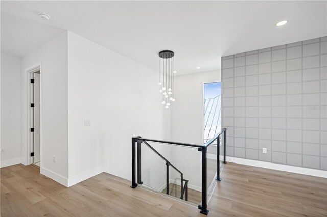 interior space with an upstairs landing, light wood-style floors, recessed lighting, and baseboards