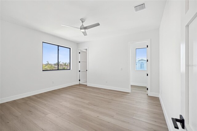 unfurnished room featuring visible vents, ceiling fan, light wood-type flooring, and baseboards