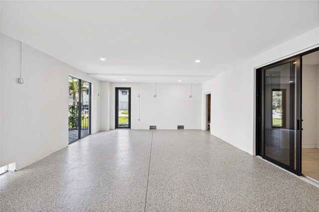 unfurnished room featuring recessed lighting and speckled floor