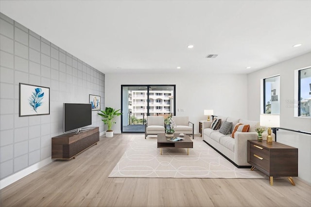 living room with light wood-type flooring and tile walls