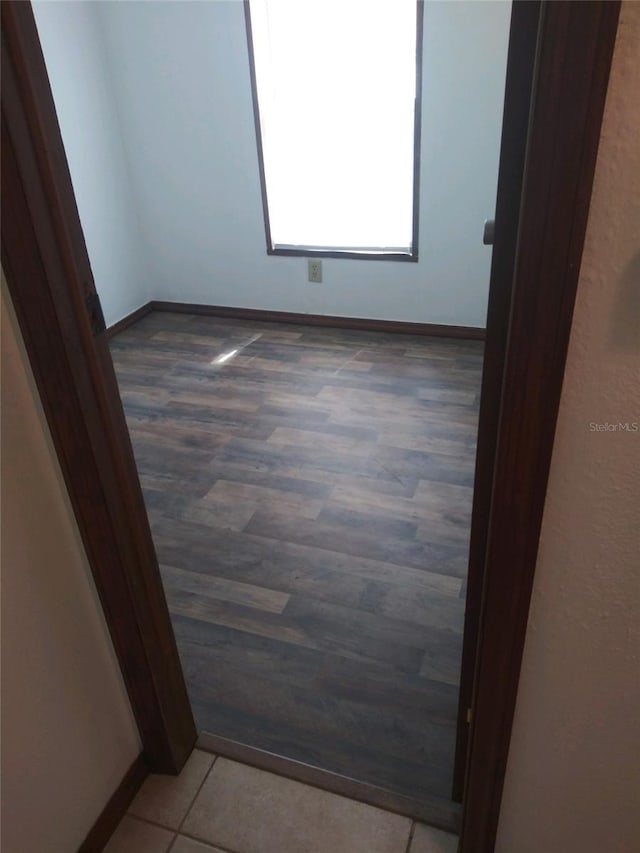 spare room featuring wood finished floors and baseboards