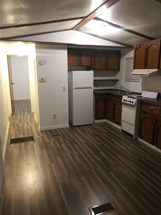 kitchen featuring dark wood-style floors, dark countertops, visible vents, white appliances, and under cabinet range hood