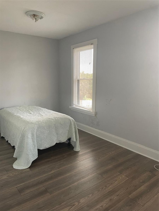 bedroom with dark wood-type flooring