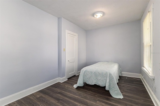 bedroom with dark wood-type flooring and a textured ceiling