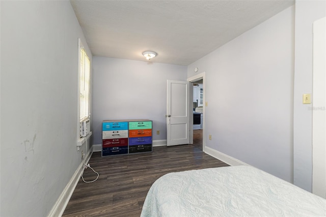 bedroom with a textured ceiling and dark hardwood / wood-style floors