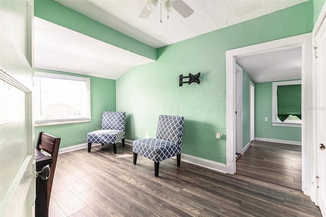 sitting room with a textured ceiling, ceiling fan, dark wood-type flooring, and vaulted ceiling