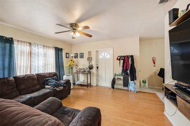 living room with light hardwood / wood-style flooring and ceiling fan