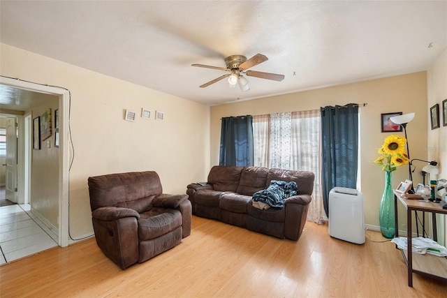 living room with light hardwood / wood-style floors and ceiling fan