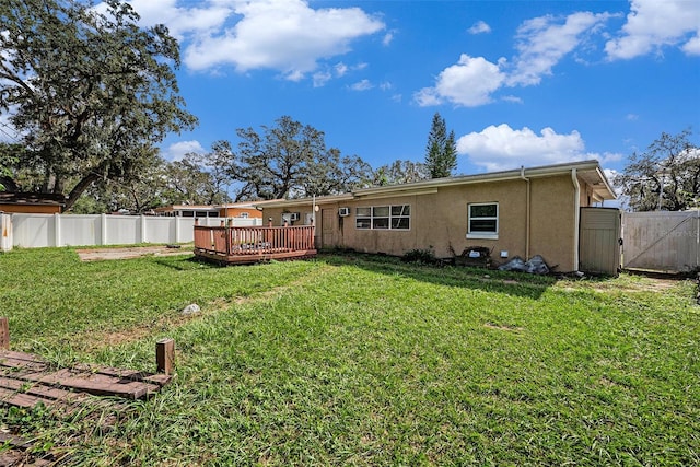 back of property featuring a deck and a lawn