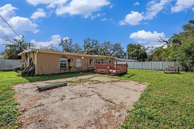 rear view of house featuring a yard and a deck