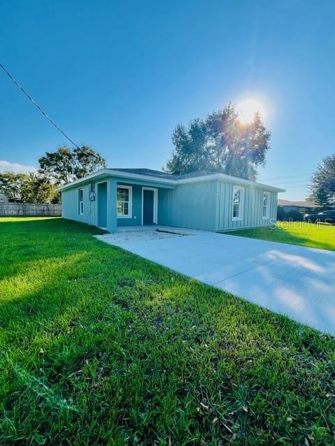 rear view of property featuring a yard and a patio area