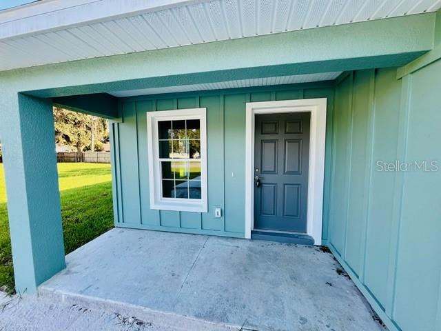 doorway to property featuring a lawn