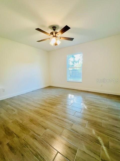 spare room with light wood-type flooring and ceiling fan