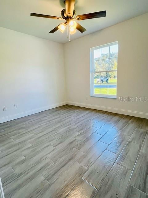 empty room with light hardwood / wood-style flooring and ceiling fan