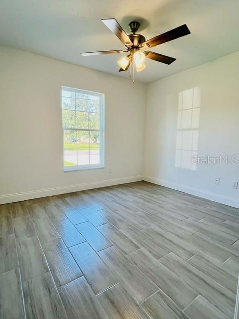 empty room with light hardwood / wood-style flooring and ceiling fan