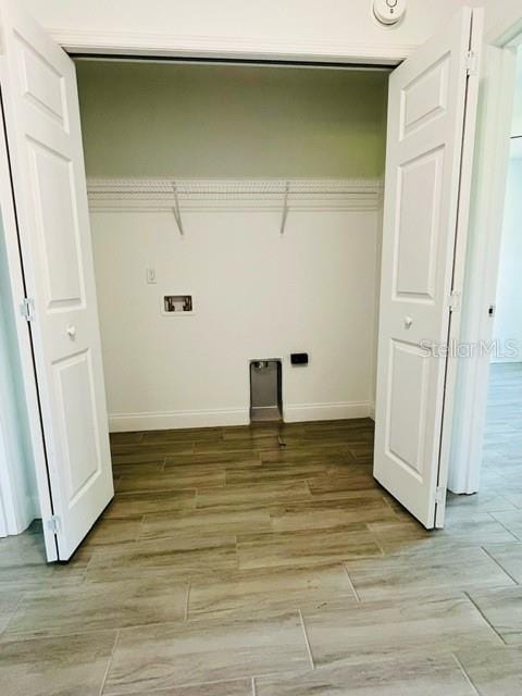 washroom with washer hookup and light hardwood / wood-style flooring